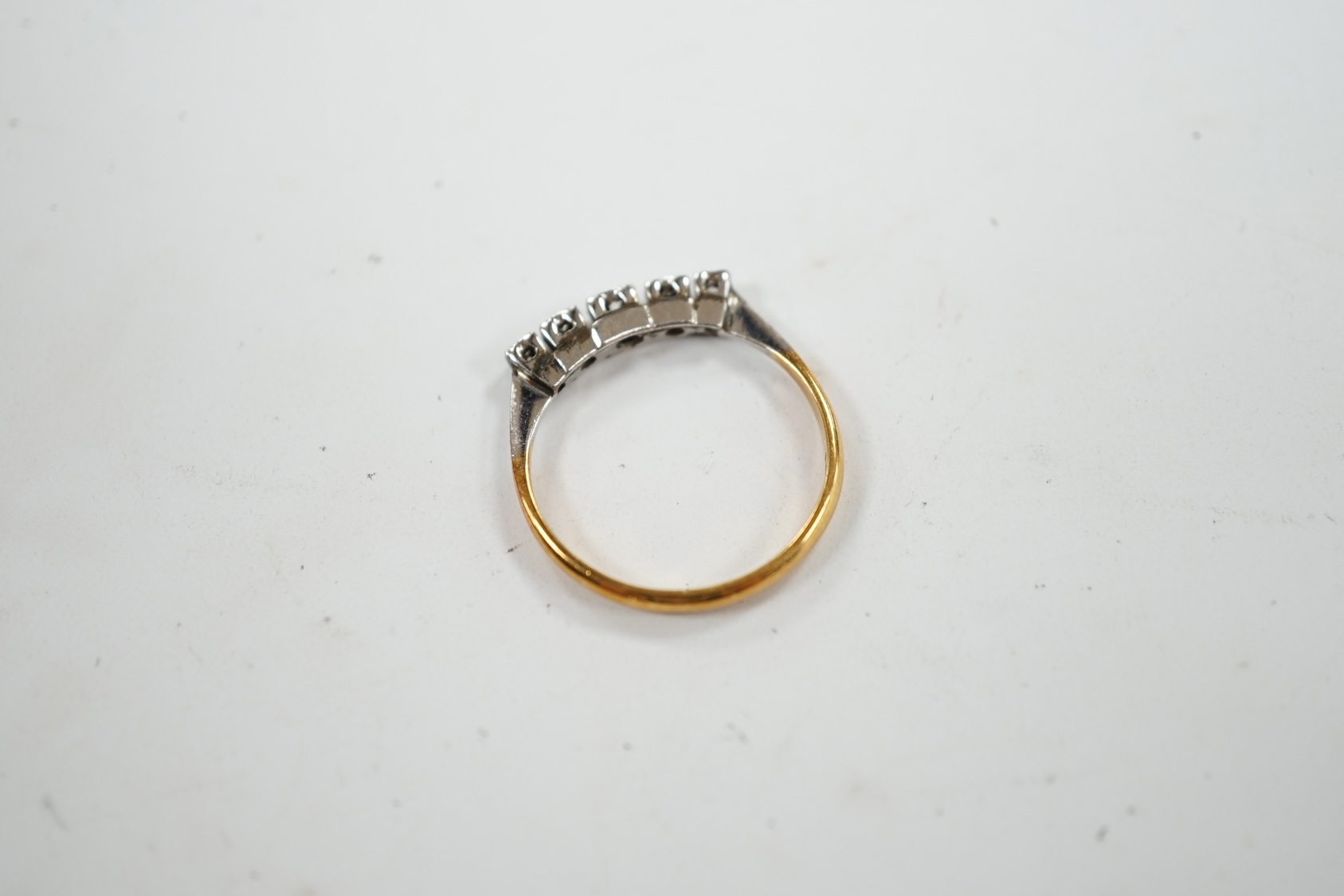 An 18ct and graduated five stone diamond chip set half hoop ring, size N, gross weight 2.5 grams. Condition - poor to fair